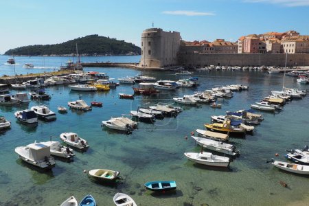 Photo for Dubrovnik, Croatia, 08.14. 2022 City port summer tourist attraction. Tourists walk, get into boats and ships and go on boat trips. Adriatic Sea. Travel and recreation. Private boats of local citizens - Royalty Free Image