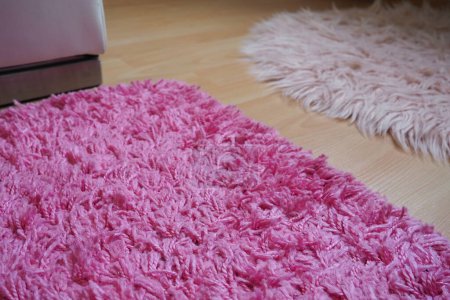 Photo for Long pile rug in pink on a beige laminate floor. Feminine interior for a room or bedroom of a girl or woman. Interior design in pink tones. Flooring is laminate. The role of dust mites in allergies - Royalty Free Image