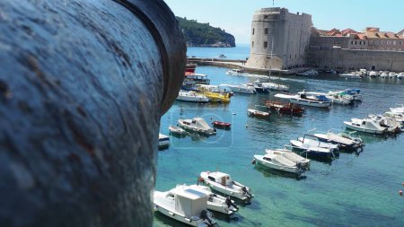 Photo for Dubrovnik, Croatia, 08.14. 2022 City port summer tourist attraction. Tourists walk, get into boats and ships and go on boat trips. Adriatic Sea. Travel. Cannon muzzle. Private boats of local citizens - Royalty Free Image
