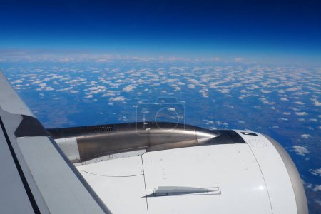 Photo for Aircraft engine and wing on the border of atmosphere and space. The edge of the troposphere. Horizon over the Earth. Flights, travel and tourism. View from a window or porthole. Clouds and blue sky - Royalty Free Image