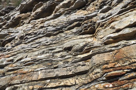 Photo for Flysch is a series of marine sedimentary rocks that are predominantly clastic in origin and are characterized by the alternation of lithological layers. Balkans, Montenegro, Budva, Mogren beach. - Royalty Free Image