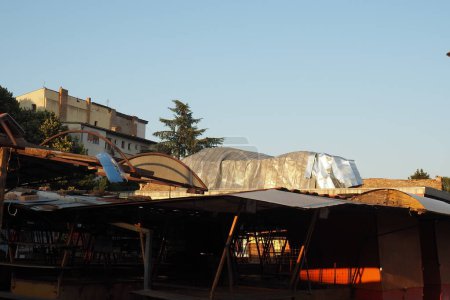 Photo for Aftermath of the hurricane 07,19,23 Sremska Mitrovica, Serbia. An aluminum sheet, a ripped roof that flew off onto a brick building. Metal decking sheet. State of emergency after a catastrophic storm - Royalty Free Image