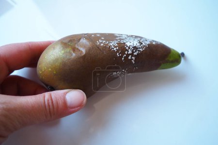 The pear became moldy. A mold or mould. The dust-like colored appearance of molds is due to the formation of spores containing fungal secondary metabolites. Perishable food products. White background