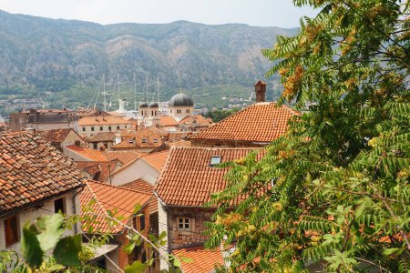 Kotor est une ville côtière du Monténégro. Baie de Kotor. Toits de tuiles rouges, montagne et cheminées d'un navire touristique. Excursions et tourisme. Cathédrale Saint-Tryphon. Vieilles villes médiévales de l'Adriatique.
