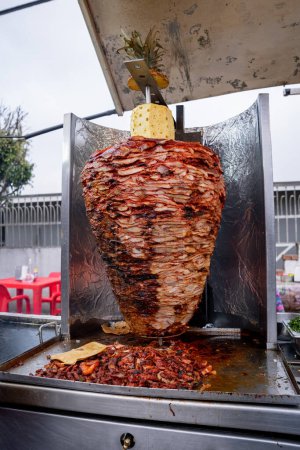 Photo for Mexican al pastor style meat, grilled, at a taco stand on the street. - Royalty Free Image