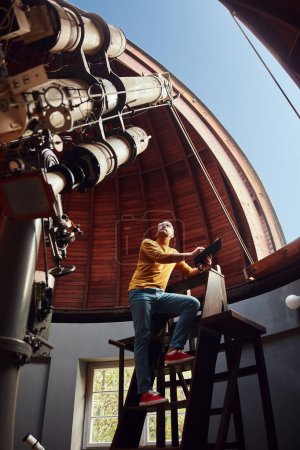 Photo for Astronomer with a big astronomical telescope in observatory doing science research. - Royalty Free Image