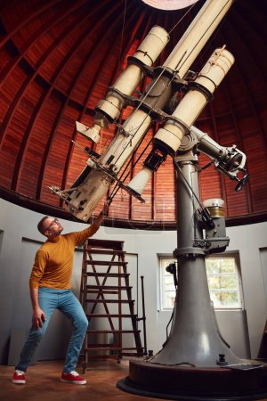 Foto de Astrónomo con un gran telescopio astronómico en el observatorio haciendo investigación científica. - Imagen libre de derechos
