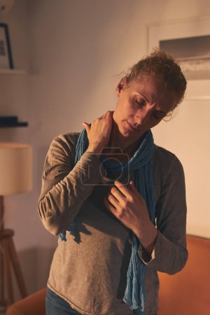 Foto de Mujer con problemas de cuello y hombros en casa. - Imagen libre de derechos