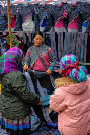 Foto de Can Cau, Vietnam - 17 de diciembre de 2022: Un vendedor de ropa en el mercado Can Cau en la provincia de Lao Cai, Vietnam. - Imagen libre de derechos