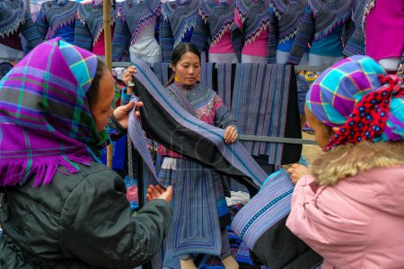 Téléchargez les photos : Can Cau, Vietnam - 17 décembre 2022 : Un vendeur de vêtements sur le marché de Can Cau dans la province de Lao Cai, Vietnam. - en image libre de droit