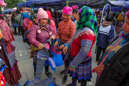 Téléchargez les photos : Bac Ha, Vietnam - 18 décembre 2022 : Une femme vendant des vêtements traditionnels au marché de Bac Ha au Vietnam. - en image libre de droit