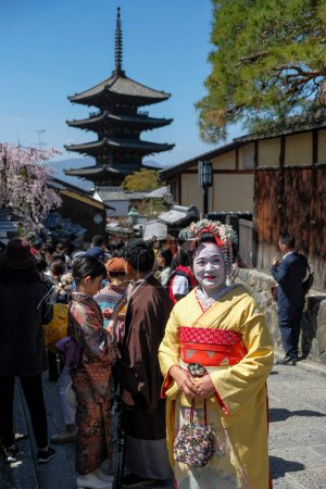 Foto de Kyoto, Japón - 28 de marzo de 2023: Una mujer vestida de geisha en Sannenzaka, un camino peatonal pavimentado de piedra en Kyoto, Japón. - Imagen libre de derechos