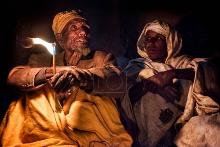 Foto de Lalibela, Etiopía - 7 de enero de 2018: Peregrinos rezando con velas encendidas por la noche fuera del Biete Medhane Alem (Casa del Salvador del Mundo). Durante los primeros días de enero, miles de peregrinos cristianos ortodoxos etíopes van a la ciudad o - Imagen libre de derechos