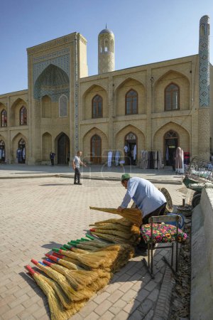 Téléchargez les photos : Namangan, Ouzbékistan - 16 octobre 2023 : Un vendeur de balais devant la Madrasa du mollah kirghize à Namangan, Ouzbékistan. - en image libre de droit
