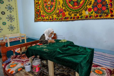 Foto de Margilan, Uzbekistán - 20 de octubre de 2023: Una mujer haciendo un tapiz con seda en Margilan, Uzbekistán. - Imagen libre de derechos
