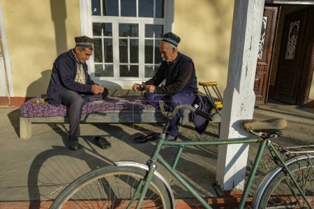 Téléchargez les photos : Istaravshan, Tadjikistan - 26 novembre 2023 : Deux hommes jouent aux cartes à Istaravshan, Tadjikistan. - en image libre de droit