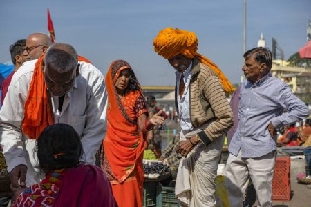 Téléchargez les photos : Nashik, Inde - 25 janvier 2024 : Un homme turban achète des fruits au Ganga Ghat à Nashik, en Inde. - en image libre de droit