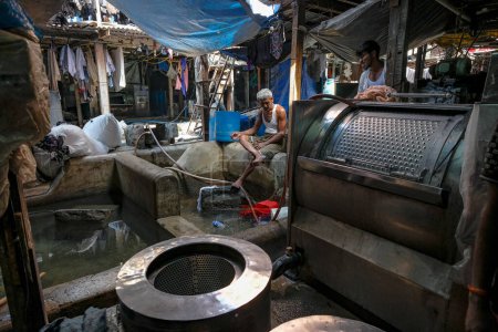 Téléchargez les photos : Mumbai, Inde - 3 mars 2024 : Hommes travaillant à Mahalaxmi Dhobi Ghat, la plus grande blanchisserie en plein air de Mumbai, Inde. - en image libre de droit