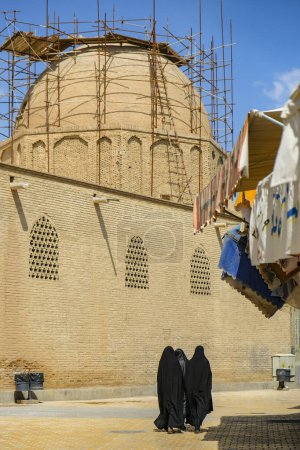 Foto de Isfahán, Irán - 1 de abril de 2024: Mujeres caminando junto a la Mezquita Jameh, también conocida como la Mezquita Atiq en Isfahán, Irán. - Imagen libre de derechos