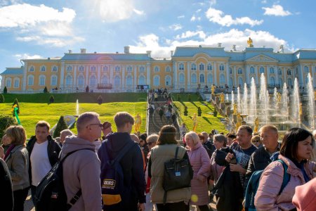 Foto de San Petersburgo - Rusia 4 de octubre de 2022: Petergof. Gran Palacio, fuentes y muchos turistas en el parque inferior de Peterhof en un día soleado brillante. Otoño. - Imagen libre de derechos