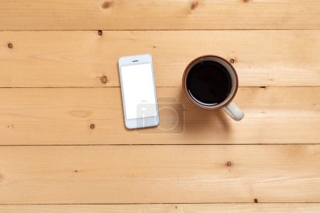 Foto de Cerrar teléfono inteligente con taza de café en la vista superior de la mesa de madera. - Imagen libre de derechos