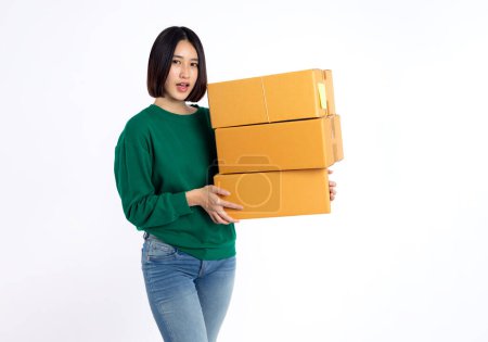 Glücklich asiatische junge Frau tragen grünes Hemd mit Paketkasten isoliert auf weißem Hintergrund, Lieferkurier und Versand-Service-Konzept,