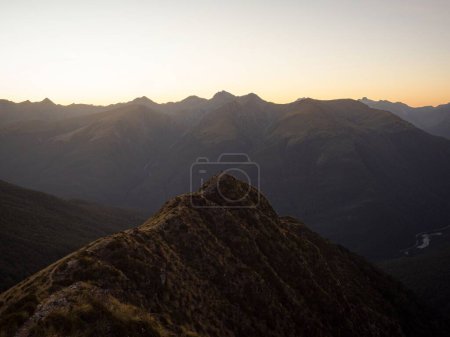 Photo for Young female woman hiking along scenic idyllic remote alpine mountain ridge path hill trail at Brewster Hut above Haast Valley, West Coast Southern Alps New Zealand - Royalty Free Image