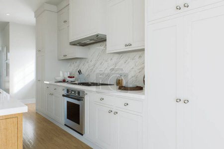 Téléchargez les photos : Cuisine avec armoires blanches, appareils de cuisine et planchers de bois. Mur de cuisine avec vaisselle. rendu 3D - en image libre de droit
