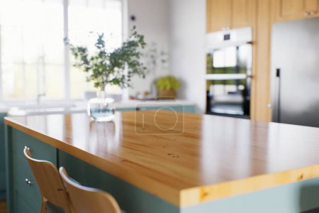 Photo for Kitchen with green cabinets, large window in the background and accent countertop to advertise the product. Kitchen island with blurry long shot of green kitchen. 3D rendering. - Royalty Free Image