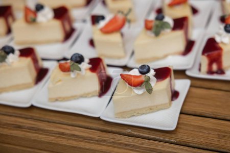 Foto de Pieza de pastel de queso con mermelada de mora y un pedazo de fresa cortado mas una arandano horizontal - Imagen libre de derechos