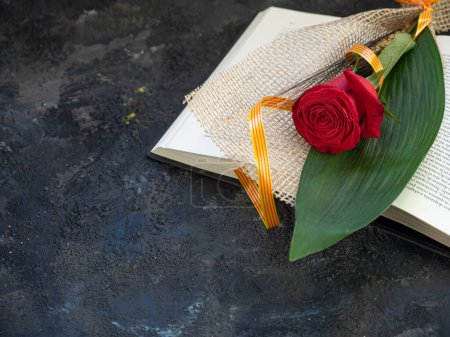 Téléchargez les photos : Rose rouge avec pointe et drapeau avec un livre. Cadeau traditionnel pour Sant Jordi, Saint Georges. C'est la version catalane de la Saint-Valentin. Espace pour la copie - en image libre de droit