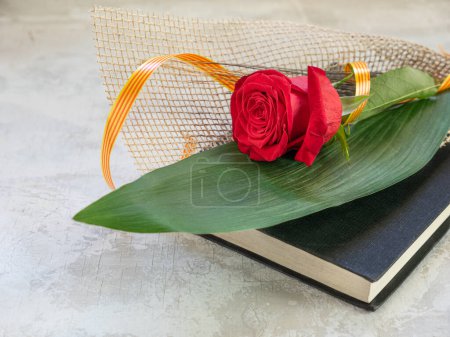 Téléchargez les photos : Rose rouge avec pointe et drapeau avec un livre. Cadeau traditionnel pour Sant Jordi, Saint Georges. C'est la version catalane de la Saint-Valentin. Espace pour la copie - en image libre de droit