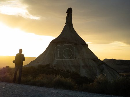Photo for Man contemplating the sunset on Mount Castilldetierra, in the desert of the Bardenas Reales of Navarra, Spain. - Royalty Free Image