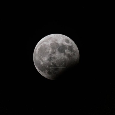 Vollmond mitten in der Nacht mit partieller Mondfinsternis. Schwarzer Hintergrund, Kopierraum.