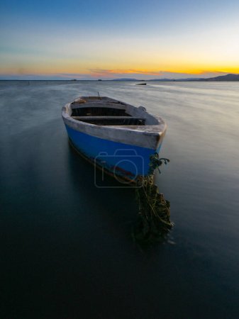 Foto de Barco anclado en la playa al atardecer. Concepto de pesca. - Imagen libre de derechos