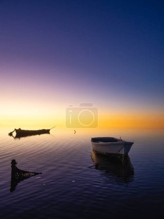Foto de Varios barcos anclados en la playa al atardecer con un cielo infinito. Concepto de pesca. - Imagen libre de derechos