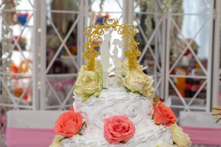 Photo for Wedding cake with figurines of newlyweds and red roses, close-up. - Royalty Free Image