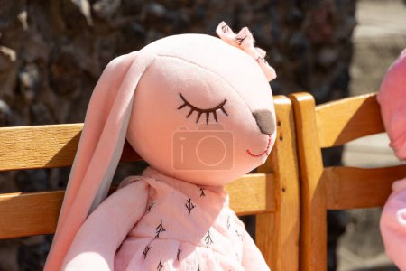 Téléchargez les photos : Gros plan du lapin en peluche. Un lapin en peluche est assis sur une chaise. - en image libre de droit
