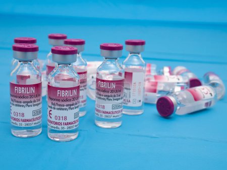 Photo for Madrid, Madrid, Spain - 02 15 2023: Bottles of Fibrilin (sodium heparin) with maroon caps and the liquid inside. Text: "Vial, bottle, 3 ml ampoule, catheter lavage." On a sterile blue surgical blanket - Royalty Free Image
