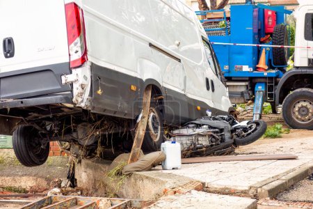 Photo for El Alamo, Madrid, Spain; 09-04-2023: Destroyed van on top of a motorcycle after both were swept away by the force of falling water in a summer storm - Royalty Free Image