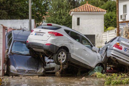 Photo for Villamanta, Madrid, Spain; 09-05-2023: Pile of cars piled up and destroyed at the end of a street after a strong summer storm having been carried away by the force of water and mud - Royalty Free Image