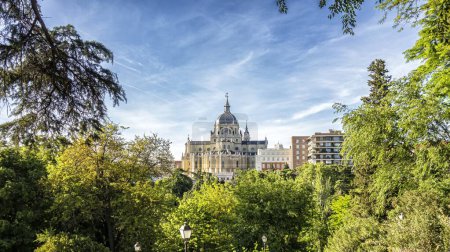 Almudena-Kathedrale von Madrid, neoklassischer Stil an einem Frühlingstag unter den Bäumen des Vistillas-Gartens