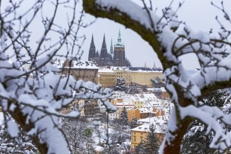 Foto de Ciudad de Praga nevada con el castillo gótico de la colina Petrin, República Checa - Imagen libre de derechos