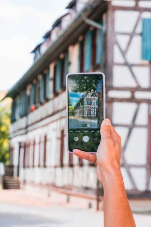 Foto de Phone in the hands of a girl photographing an old house - Imagen libre de derechos