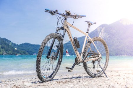 Foto de The bike stands against the backdrop of mountains and a lake - Imagen libre de derechos