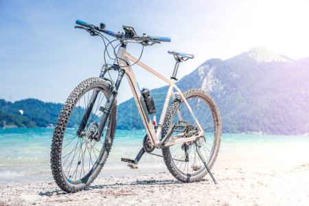 Foto de The bike stands against the backdrop of mountains and a lake - Imagen libre de derechos