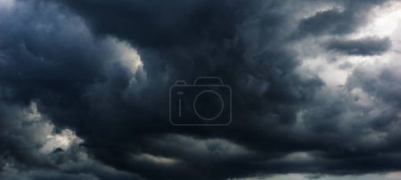 Foto de El cielo oscuro con nubes pesadas convergiendo y una tormenta violenta antes de la lluvia.Mal o mal tiempo cielo y el medio ambiente. emisiones de dióxido de carbono, efecto invernadero, calentamiento global, cambio climático. - Imagen libre de derechos