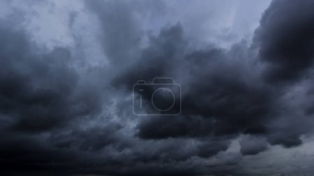 Foto de El cielo oscuro con nubes pesadas convergiendo y una tormenta violenta antes de la lluvia.Mal o mal tiempo cielo y el medio ambiente. emisiones de dióxido de carbono, efecto invernadero, calentamiento global, cambio climático - Imagen libre de derechos