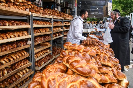 Téléchargez les photos : Pèlerins juifs ultra-orthodoxes achètent du pain traditionnel Challah dans la rue près de la tombe du rabbin Nachman lors de la célébration de la fête de Roch Hashanah, le Nouvel An juif, Uman, Ukraine, 15-09-2023. - en image libre de droit