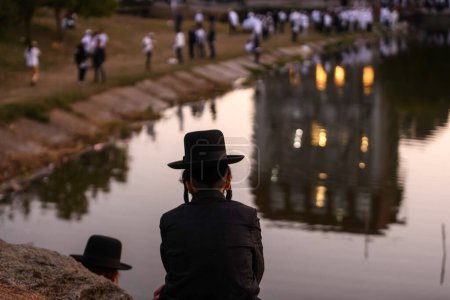 Téléchargez les photos : Les pèlerins juifs orthodoxes prient sur le bord du lac près de la tombe du rabbin Nachman tout en célébrant Roch Hashanah, le Nouvel An juif, au milieu de la Russie continue la guerre en Ukraine. Uman, Ukraine 16-09-2023 - en image libre de droit